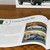 A close-up of the Porsche Advent Calendar's companion book, open to a page showing photos of the Porsche 965 prototype.
