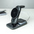 The black 3-in-1 charging station on a white desk, featuring a magnetic phone stand, watch charger and night light.