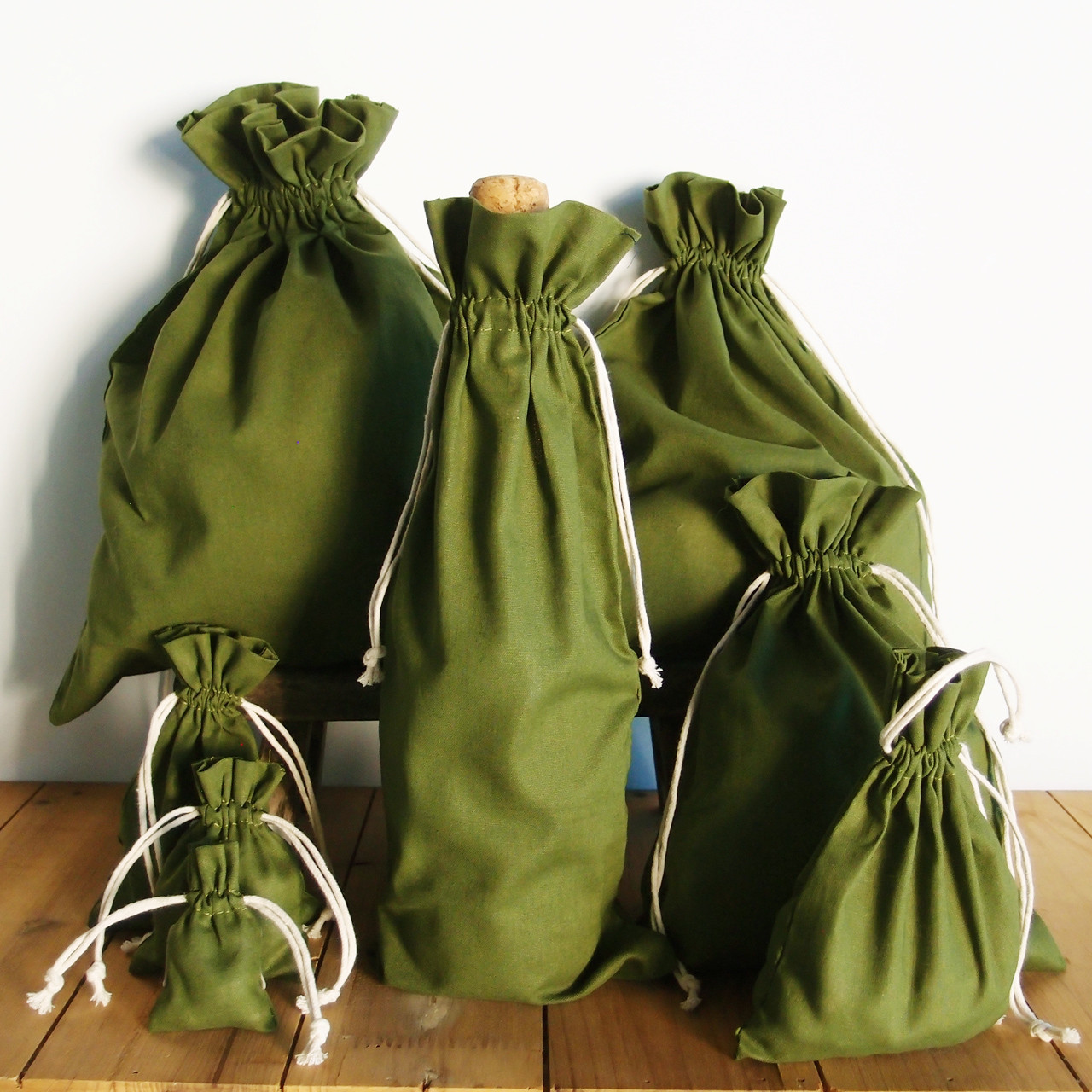Wholesale olive green cotton drawstring bags at Packaging Decor. Excellent as wine bags, party favor bags, gift packaging, wedding favor bags, jewelry product packaging, and more.
