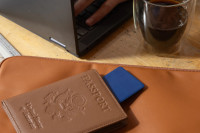 A Life360 Tile Slim - Navy Blaze inside of a passport.