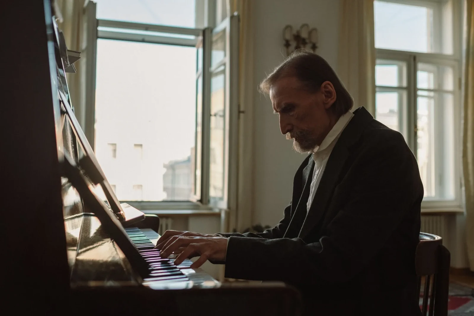 A pianist playing beside a sunlit window