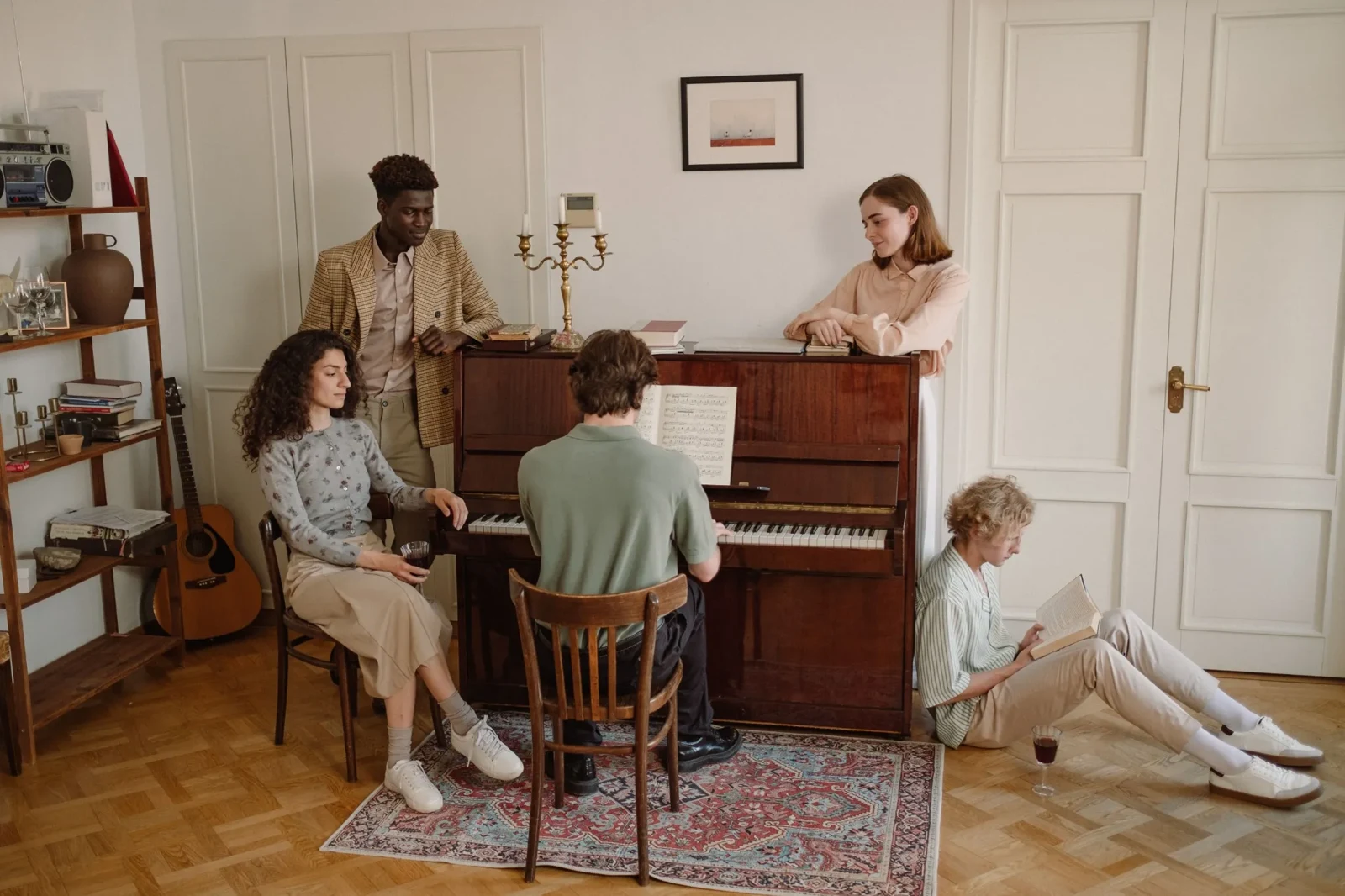 Friends sharing music around an upright piano