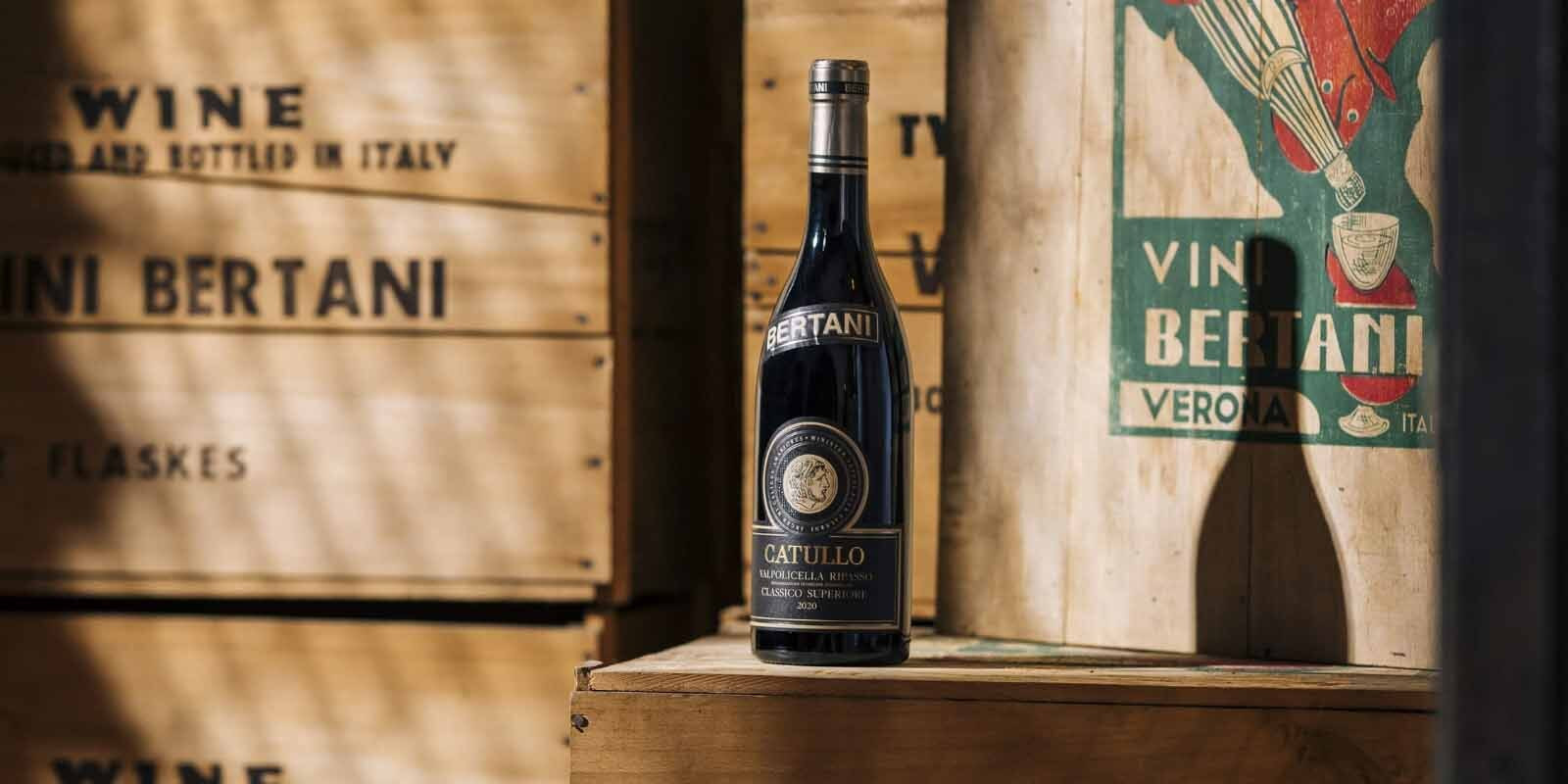 A bottle of Bertani Catullo Vapolicella Classico sits on a wooden box in the Bertani winery