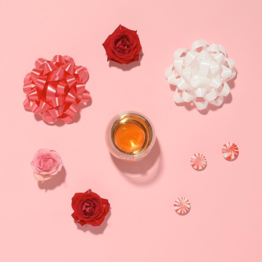 Glass of Rose in pink backdrop with flowers