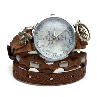 Close-up of Cuckoo Nest Art Studio blue-gray watch face with silver-tone case, patterned brown leather straps, and flower charm.