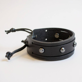 Black leather stacking bracelet with gunmetal rivets showing studded design detail