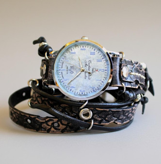 Women's leather wrap watch with hand stamped snake texture band and custom blue marbled Cuckoo Nest dial, front view on gray background