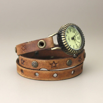 Handmade women's leather wrap watch in tan with star stamped band and antique brass face with cream dial, side angle view