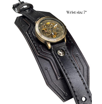 Black full-grain leather cuff watch with antique brass skeleton dial and black stitching – handmade 7-inch wrist size. Black full-grain leather cuff watch with antique brass skeleton dial and black stitching – handmade 7-inch wrist size.