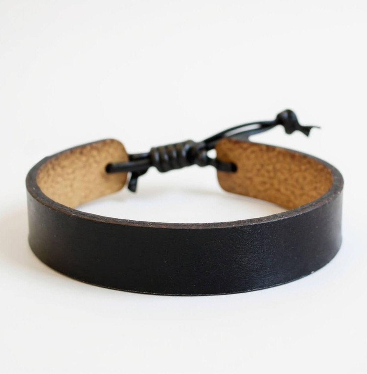 Black leather bracelet showing personalized laser engraving "#1 DAD" on inside