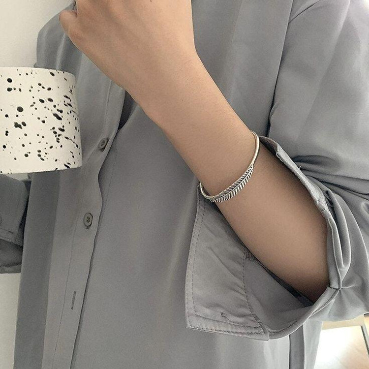 Silver leaf cuff bracelet with adjustable open design and textured leaf details.