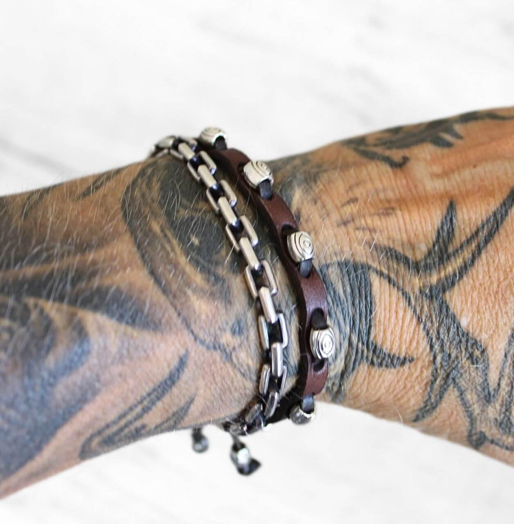 Brown leather bracelet stacked with chain on tattooed wrist