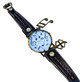 Flat lay of women's distressed black leather wrap watch featuring a 37mm musical-note dial, gold-tone buckle, decorative stitching, music note and four-leaf clover charms.