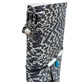 Close-up of black and white snakeskin-patterned leather journal spine with silver-tone cross charm, white bead, and metal eyelets.