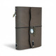 Angled view of taupe gray refillable leather journal showing curved wraparound flap, decorative charms, and notebook inserts.
