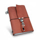 Burnt orange refillable leather journal with curved wraparound flap, silver-tone skeleton charm, and black elastic closure.