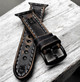 Detailed view of the buckle side of a handmade black leather Apple Watch strap with rustic edges and thick gray stitching.