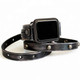 Close-up of a studded black leather Apple Watch wrap band with a worn leather finish and layered straps.