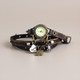 Women's vintage leather wrap watch coiled showing triple wrap band with silver beads, antique brass face and vintage charm bracelet