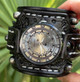 Close-up of handmade skull watch with black leather cuff and silver industrial dial
