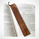 Leather bookmark personalized with engraved quote resting inside an open book