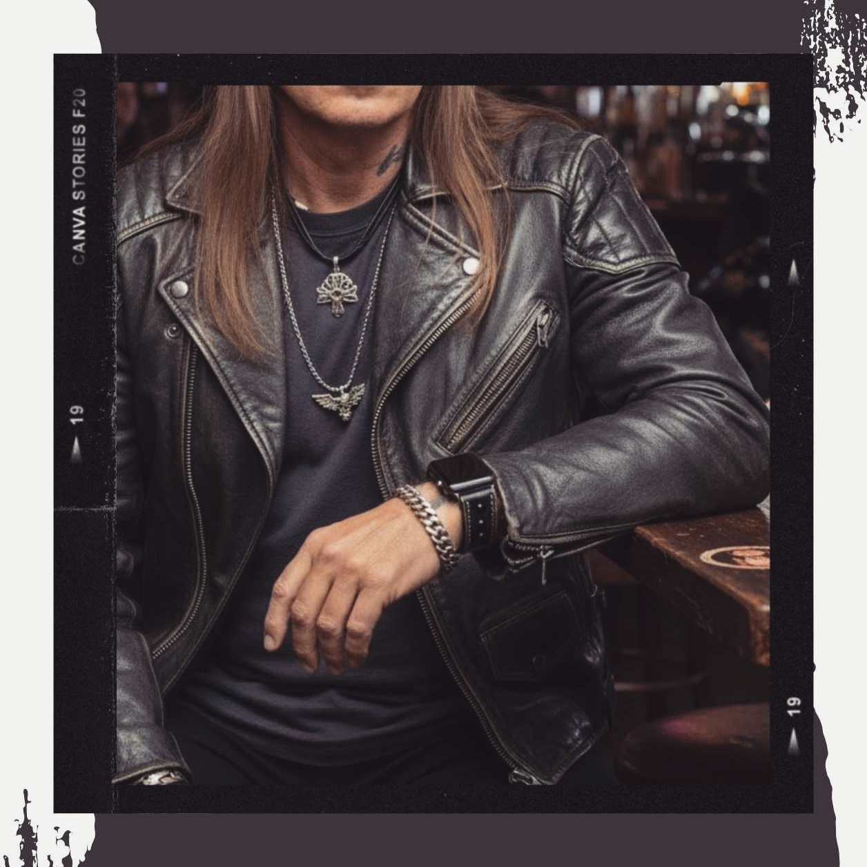 Close-up of a man wearing a black leather cuff watch with a leather jacket, rugged rocker style.