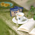 Caffe Borbone Miscela Blu - Espresso Paper Pods, steaming espresso in a white cup on a saucer with a spoon, on a rustic surface with an open book and a green plant, showcasing the coffee product. - product thumbnail