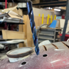 Multi-step drill bit piercing painted sheet metal surface