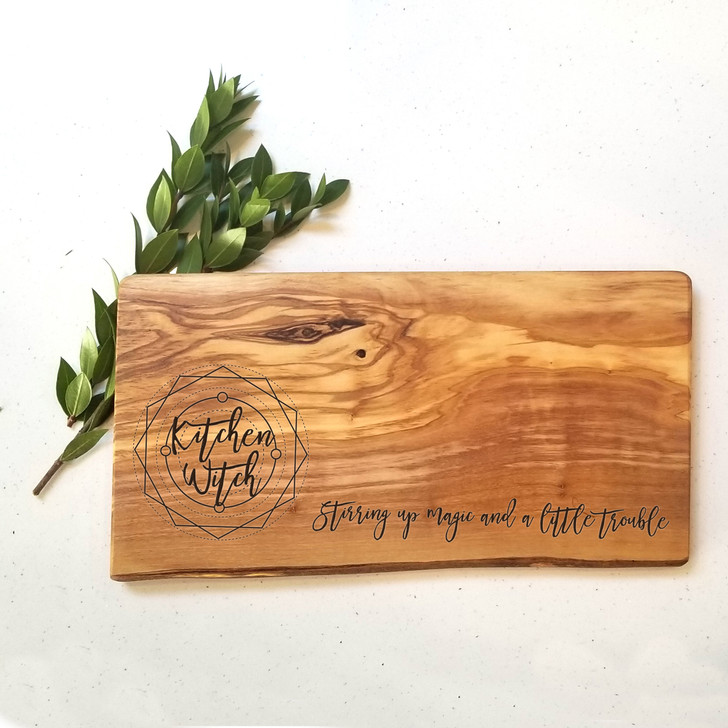 Raw edge olive charcuterie board with kitchen witch design