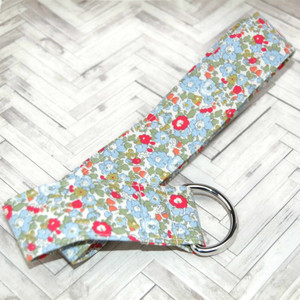 colorful blue floral fabric belt up close on wood background colorful blue floral fabric belt up close on wood background