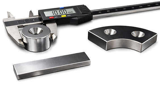Caliper measuring a ring magnet next to a block magnet and a magnet segment