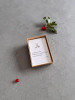 Sterling silver holly necklace on a haiku message card. The necklace is shown in it's gift box next to some festive holly.