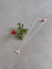 Sterling silver holly necklace shown next to a piece of festive holly.