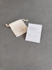 Sterling silver whale tail earrings on a haiku poem message card. The earrings are shown with a personalised gift bag.