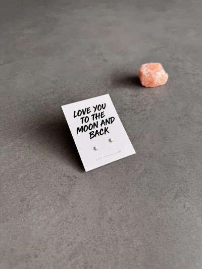 Sterling silver moon earrings on a 'Love You To The Moon And Back' message card. The earrings are shown next to a piece of pink Himalayan salt.