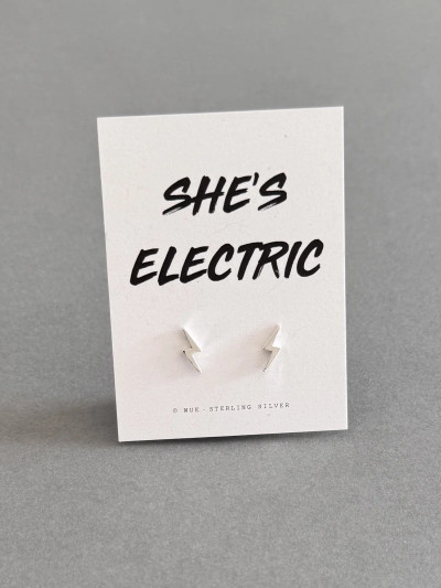 Sterling silver lightning bolt earrings on a ' She's Electric' message card. The earrings are inspired by the Oasis tour in summer 20025. Sterling silver lightning bolt earrings on a ' She's Electric' message card. The earrings are inspired by the Oasis tour in summer 20025.