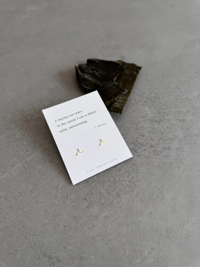 Sterling silver whale tail earrings on a haiku poem message card. Sterling silver whale tail earrings on a haiku poem message card.