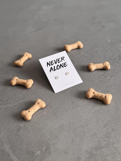 Sterling silver paw earrings on a 'Never Alone' message card. Sterling silver paw earrings on a 'Never Alone' message card.