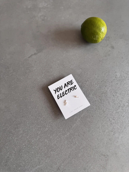 Sterling silver lightning bolt earrings on a 'You Are Electric' message card.