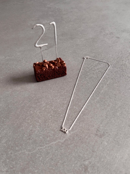 21st Birthday Gift Roman Numerals Necklace - Sterling Silver. Image also shows a piece of cake with sparklers representing 21.