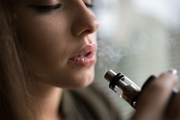 Woman Vaping Mouth to Lung