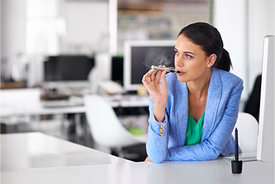 Woman Vaping CBD Vape Pen at Her Desk