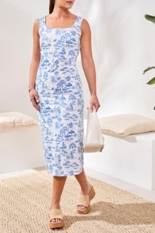 A woman in a blue tropical print midi dress