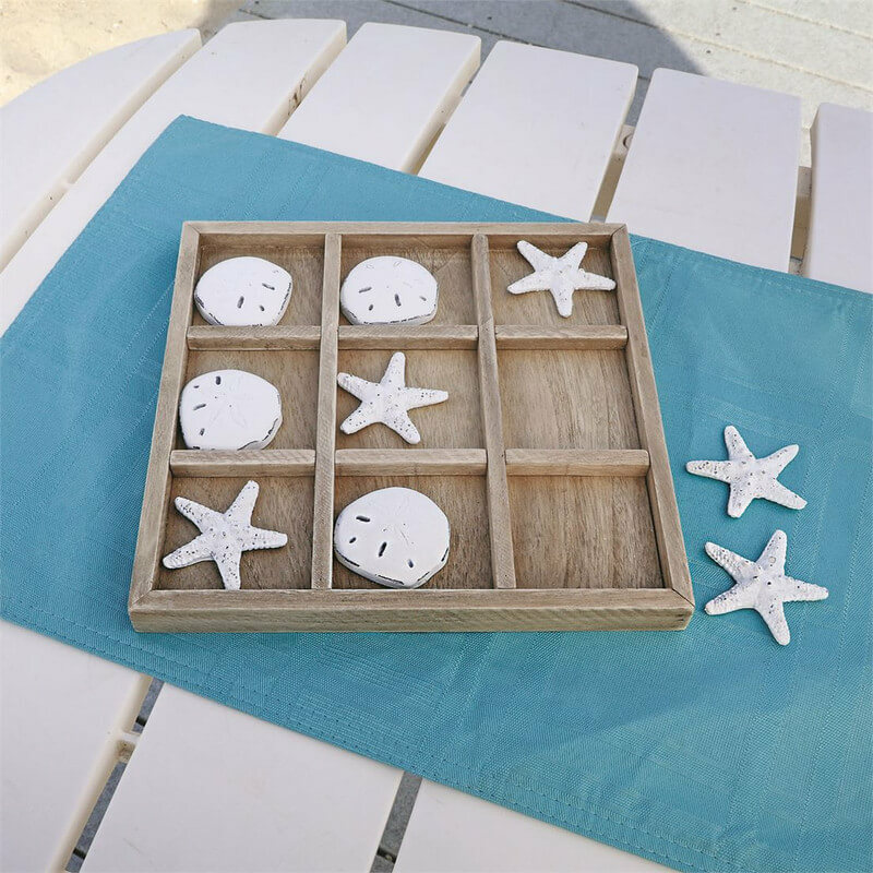 starfish and sand dollar tic tac toe wooden game on beach table