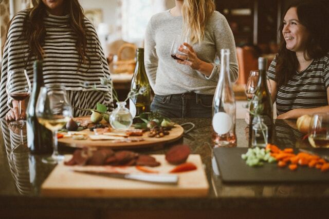 women with wine at a table with prepared food