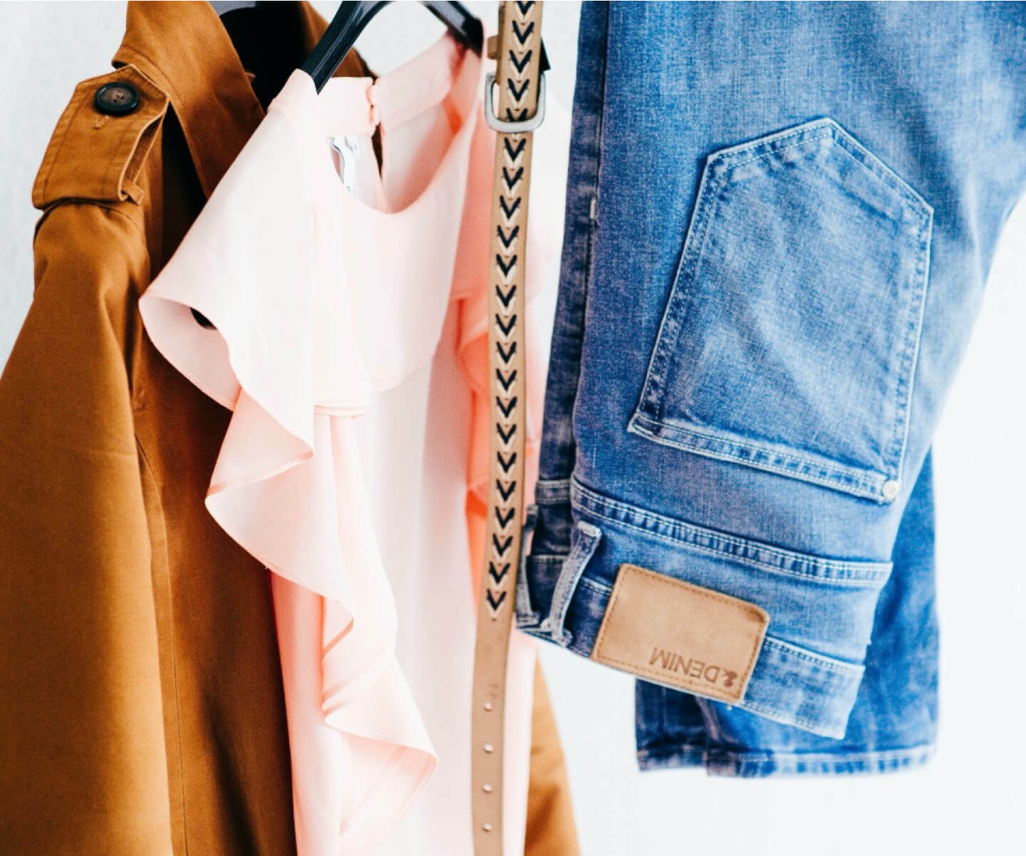 Fashionable clothes hanging on retail clothing rack