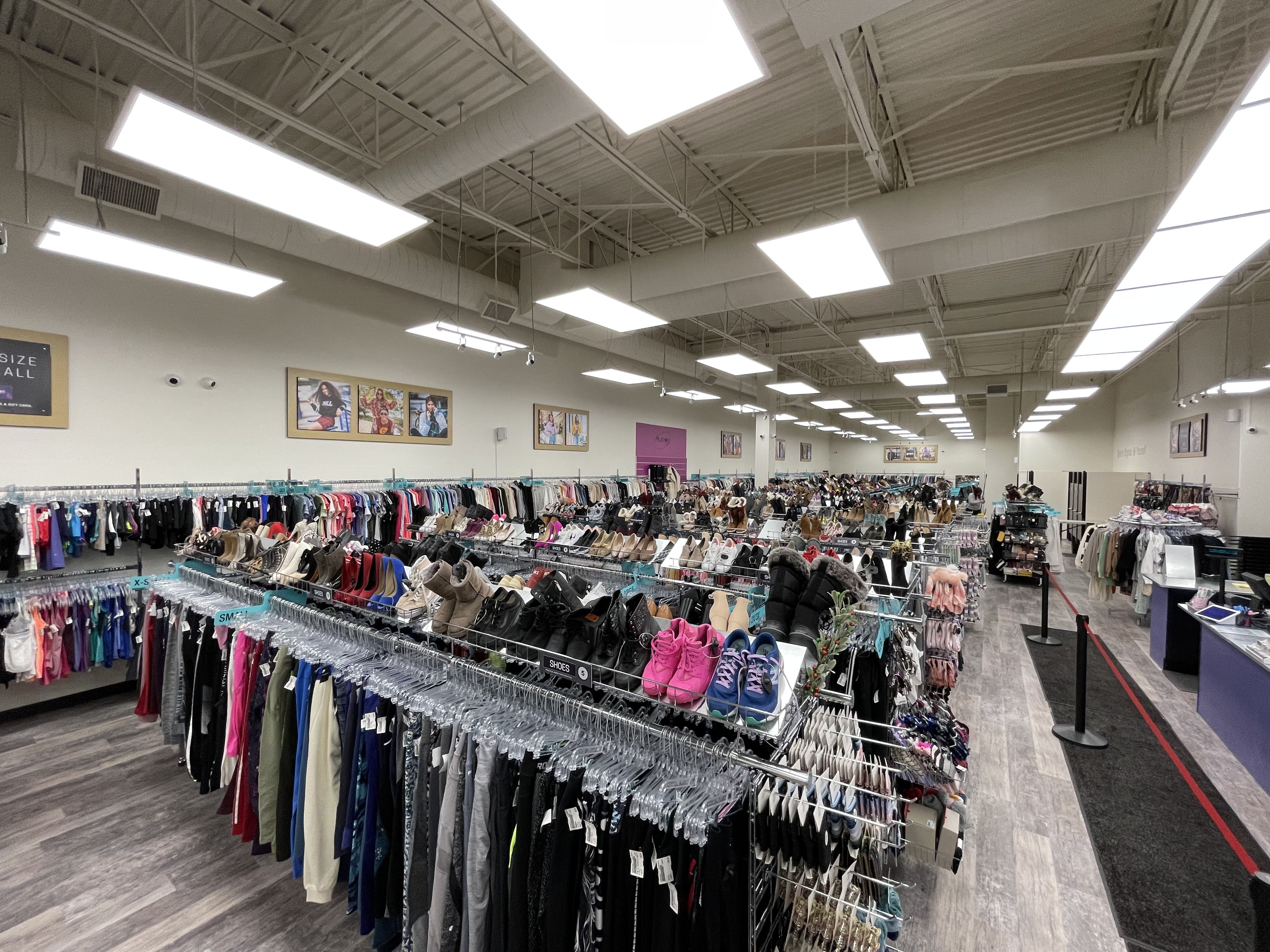 Image of inside the store, looking down an isle with racks of clothes.
