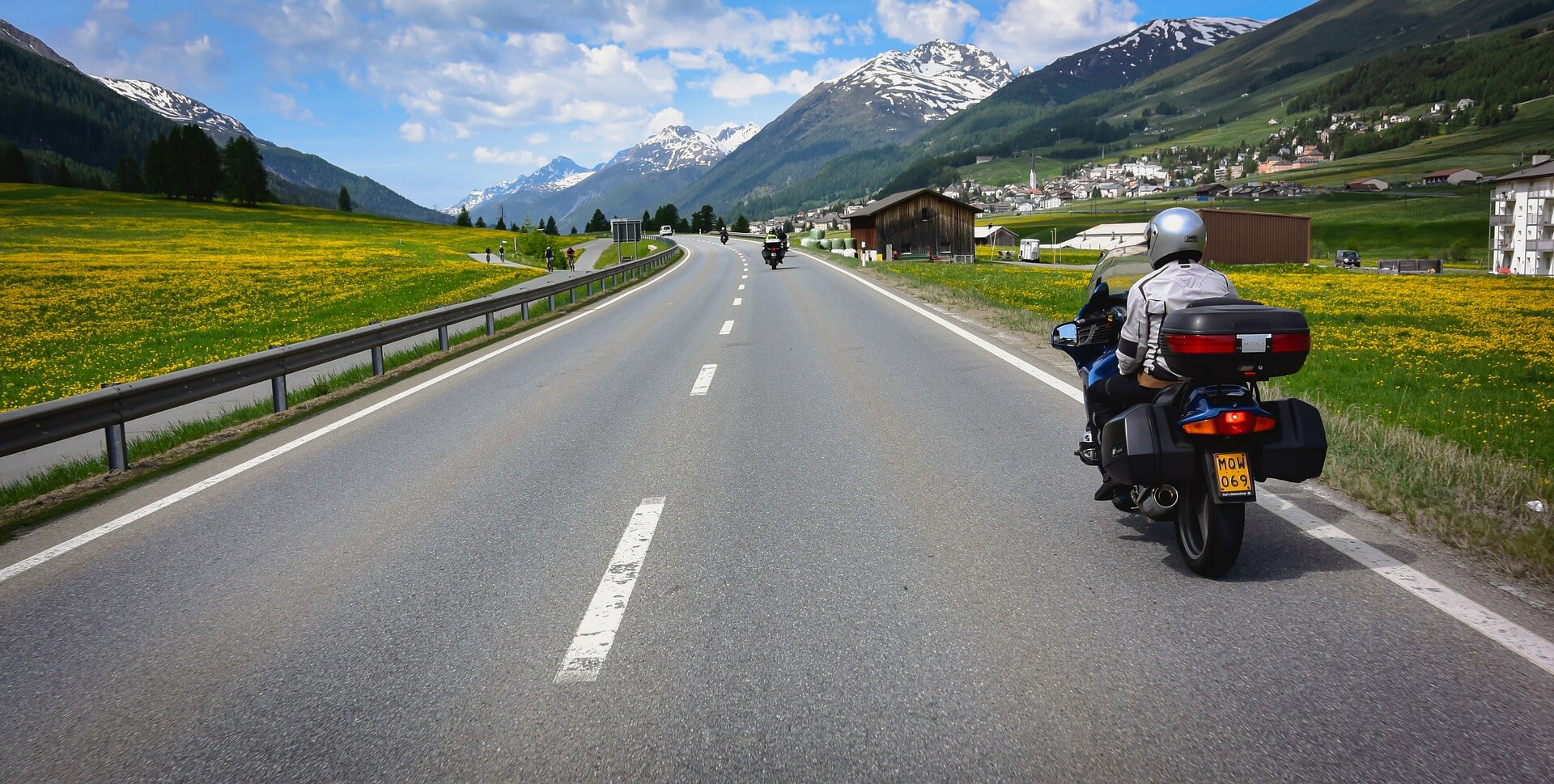 motorcycle riders on a highway with mountains ahead