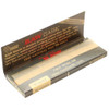 An opened pack of Raw Black Classic 1 1/4 Rolling Papers, showing the paper inside.