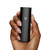 A Pax Mini Onyx being held in a hand against a white background.